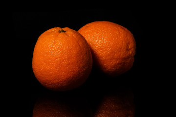 Oranges fruit on a black background with reflection