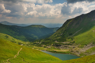 Warm summer season in the Ukrainian Carpathians with view of the observatory White elephant and tourist with a tent against the background of the mountains