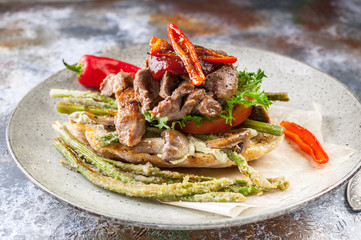 Sandwich with meat and vegetables on wooden background