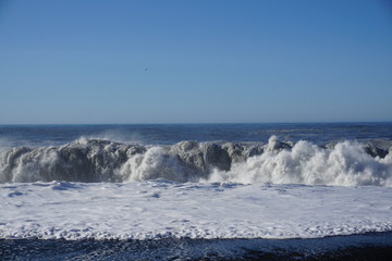Breathtaking Reynisfjara beach with rocks and blue sky on Iceland in summer