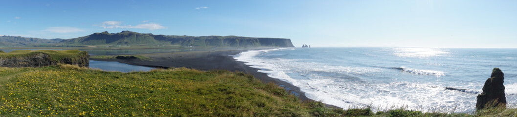 Breathtaking Reynisfjara beach with rocks and blue sky on Iceland in summer