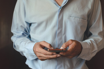 businessman using mobile phone touch screen vintage style with hands typing smart phone texting messaging lifestyle working app device technology internet social data online concept.