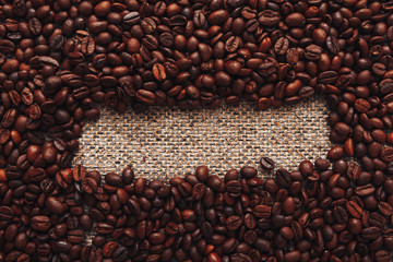 Coffee beans and sackcloth background, place for your brand