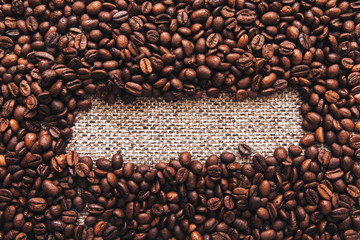 Coffee beans and sackcloth background, place for your brand
