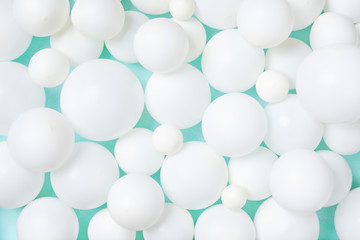 White balloons pattern on pastel mint table. Party or birthday background. Flat lay style.