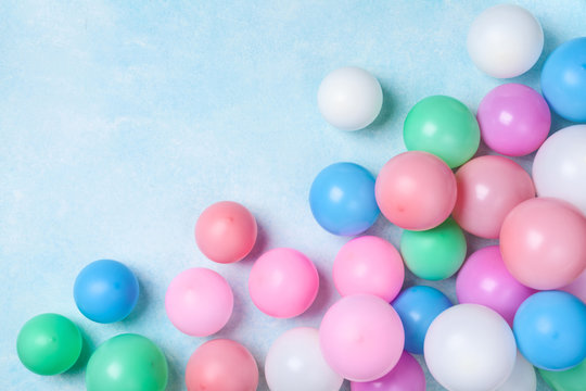 Colorful balloons on blue table top view. Birthday or party background. Flat lay style.