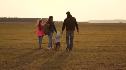 dad, mom, daughters and pets, tourists. teamwork of a close-knit family. family travels with the dog across the plains and mountains. The concept of a sports family holiday in nature.