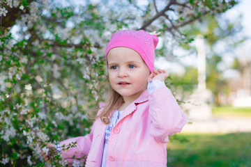  girl, pink hat and jacket, flowering trees, smile
