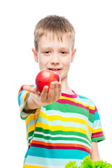 Fototapeta na wymiar Portrait of a boy with a red ripe apple in the studio on a white background is isolated