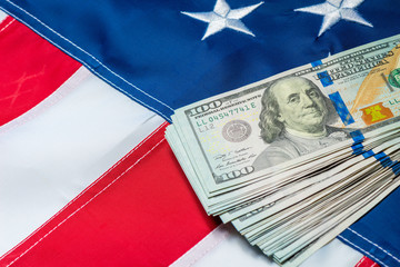 Fototapeta premium american flag closeup and a bunch of 100 dollar bills