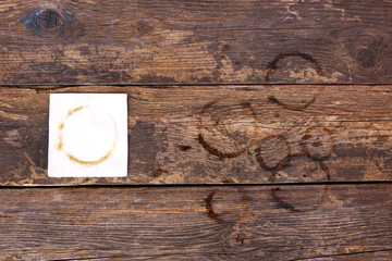 Trail from cup of coffee on napkin and on old wooden background. Top view. Flat lay.