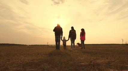 Dad, Mom, small child and daughters and pets tourists. teamwork of a close-knit family. family travels with the dog on the plain. The concept of a sports family holiday in nature.