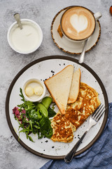 Omelet with herbs, bread and butter. Healthy breakfast with scrambled eggs and coffee.