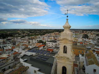 Aerial Shot of the Belltower of the Church of the Nativity in the City of Noci, Near Bari, in the South of Italy, on Partially Cloudy Sky Background