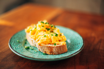 Scrambled eggs with chives on toasted bread