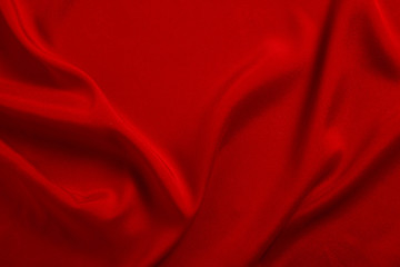 Red silk or satin luxury fabric texture can use as abstract background. Top view.