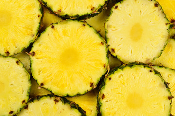 Pineapple juicy yellow slices background. Top view.