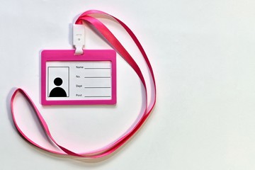 Pink new blank unfilled badge with satin ribbon on the left. On a light background to the left.