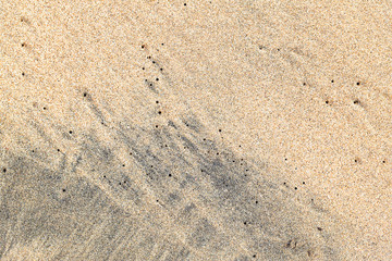 Fototapeta na wymiar Natural background of yellow and black sand.