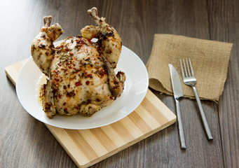 grilled chicken in spices. Spices on the skin, red pepper, sea salt. fork knife. Bouquet of laurel leaf.