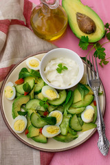 Fresh salad with avocado, cucumber, quail eggs and corn salad