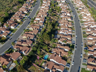 Fototapeta premium Aerial view suburban neighborhood with identical villas next to each other in the valley. San Diego, California, USA. Aerial view of residential modern subdivision luxury house with swimming pool.