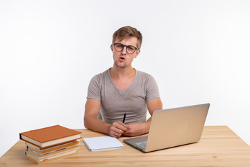 Study, education, people concept - student funny man doing exercises in netbook, looking surprised