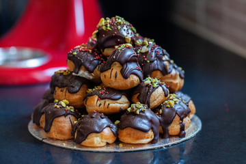 profiteroles coated with chocolate and garnished with nuts
