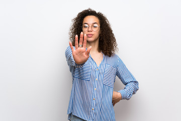 Dominican woman with striped shirt making stop gesture denying a situation that thinks wrong
