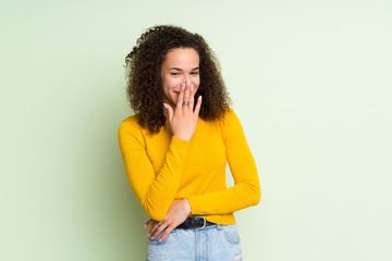 Dominican woman over isolated green background smiling a lot