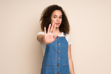 Dominican woman with overalls making stop gesture