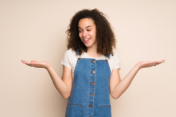 Dominican woman with overalls holding copyspace with two hands