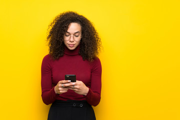 Dominican woman with turtleneck sweater sending a message with the mobile