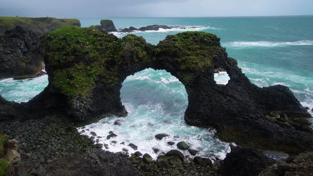 Amazing stone arch Gatklettur basalt rock on Atlantic coast of Arnarstapi in Iceland. The famous natural form arch attracts tourist to visit west of Iceland.