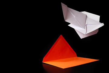 white envelopes fall on the orange envelope on top. Orange envelope lies on a black background. White and orange envelopes on a black background.