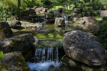 Fototapeta na wymiar Beautiful waterfalls in the City Park in spring