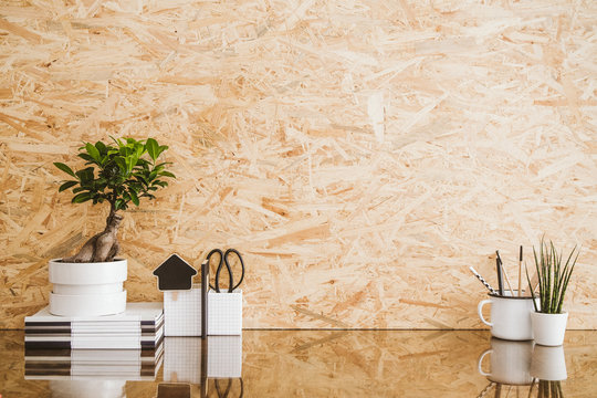 Stylish home ineterior  desk with books, plant and wooden wall mockup.