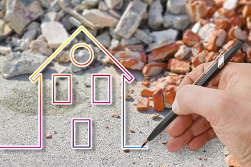Hand drawing a colored house against a concrete and brick rubble debris - earthquake reconstruction...