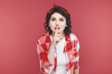 Pretty woman showing to keep silence isolated over the red studio