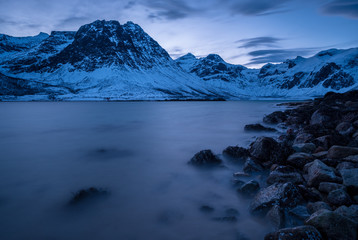 Norwegian fjord with rocks and mountains in winter at blue hour in the morning, Norway