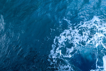 Blue sea water with white foam.Top view