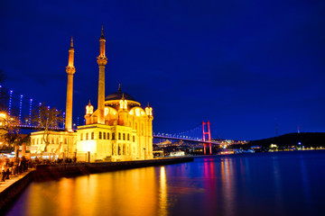 View of the Ortakoy Mosque in Istanbul City of Turkey. Historical Tower and sunset at Bosphorus.