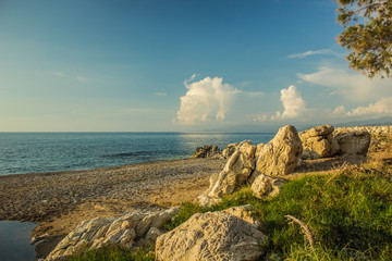 idyllic picturesque empty Greece beach summer vacation scenery landscape concept photography, sand stone coast line along Mediterranean sea and contrast blue sky with white clouds  