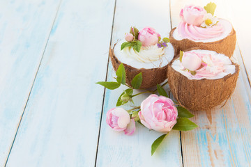 Coconut cupcakes with flowers, strawberries and cheese cream