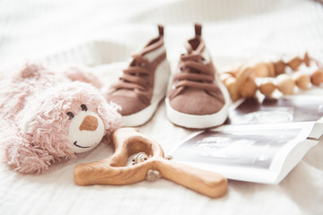 Brown booties next to baby photos with ultrasound and other objects of newborns.. The concept of awaiting baby, pregnancy