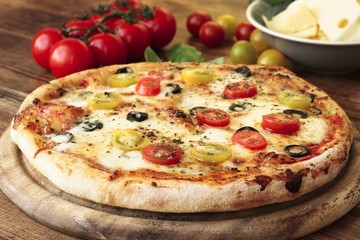American pizza with tomatoes, olives, gouda cheese and mozzarella