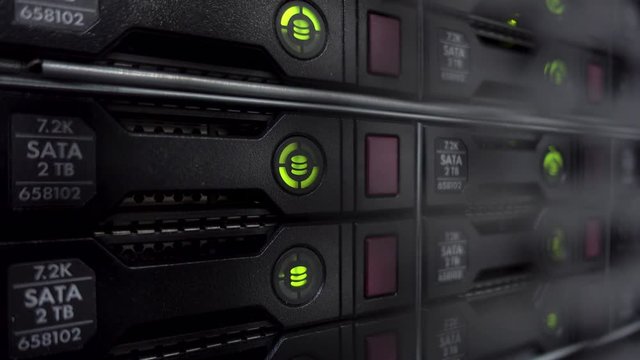Servers stack with hard drives in a datacenter for backup and data storage. Close up shot. Blink led green.