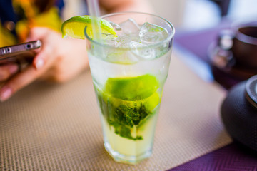 Alcoholic drink concept. Mojito with ice and lime in glass close up