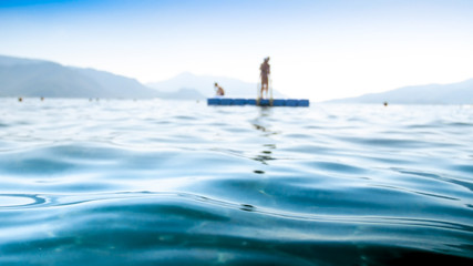 Out of focus image of calm sea waves against floating pier © Kyrylo Ryzhov