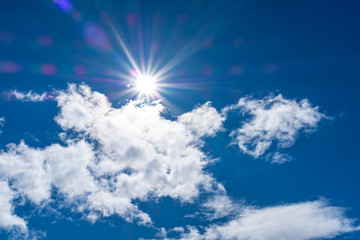 Naklejka na ściany i meble Beautiful cloudscape with sun flair and star against a blue sky